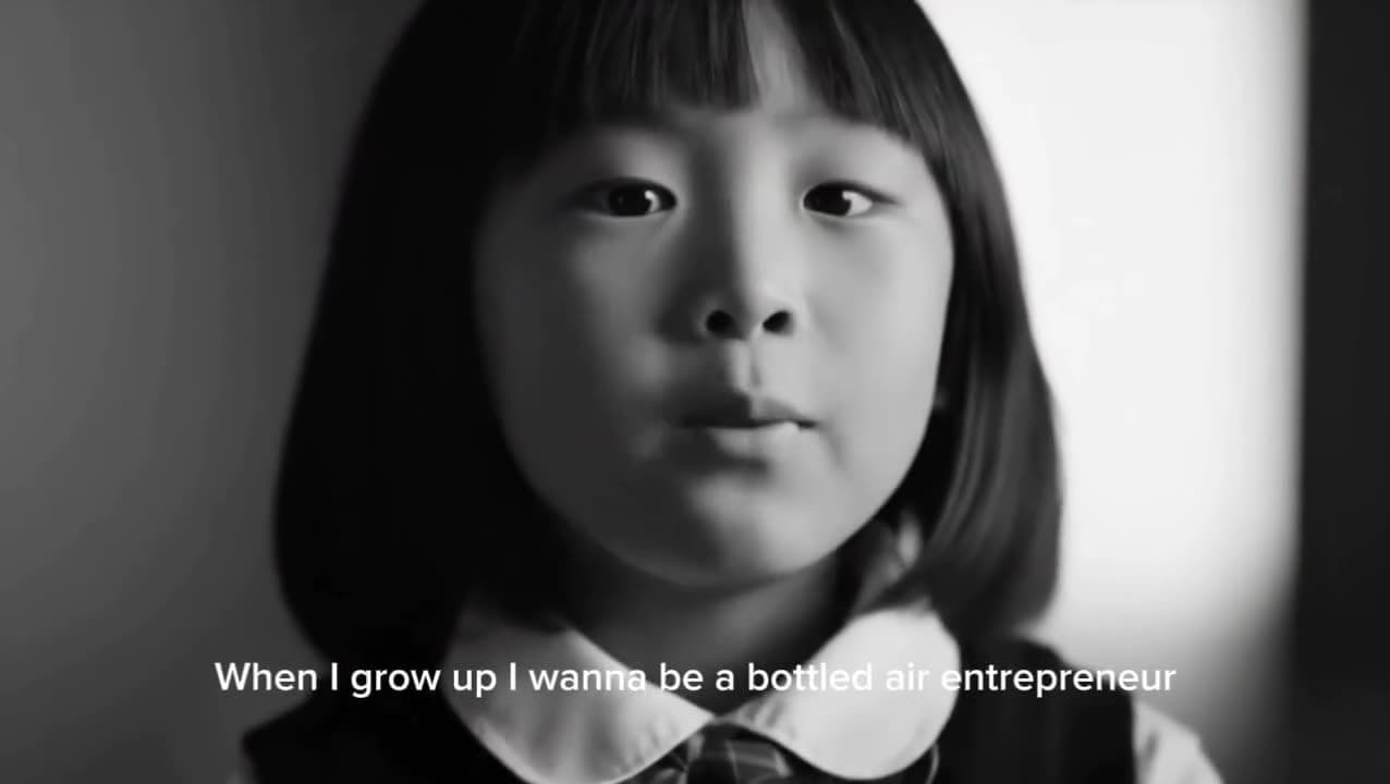 Black-and-white film still of a young girl speaking to camera