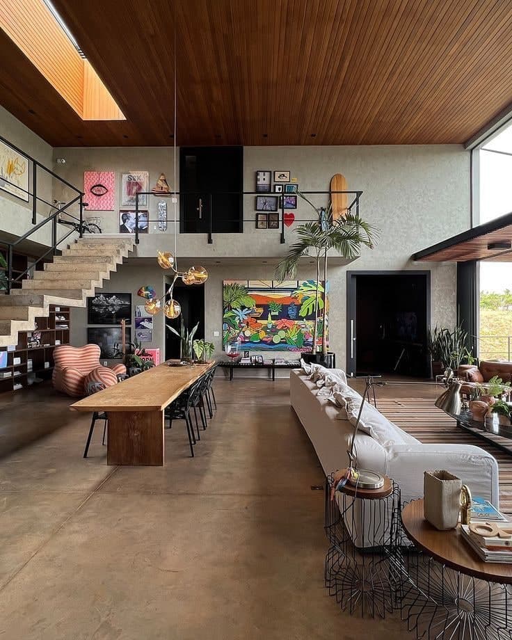 Brand photography: a warm, double-height interior with a long communal table and a staircase